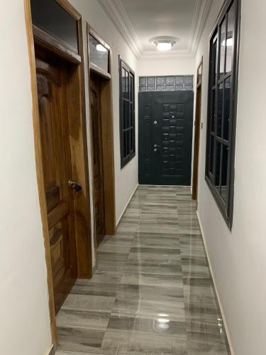 a hallway with two black doors and a tile floor at Top Base Apartments in Accra