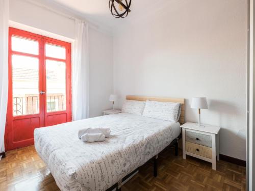 um quarto com uma cama e uma porta vermelha em El Mirador de Palacio em Madri