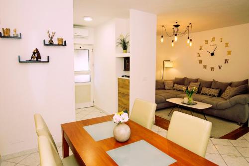 uma sala de estar com uma mesa e um sofá em Duce Apartment D&Z em Duće