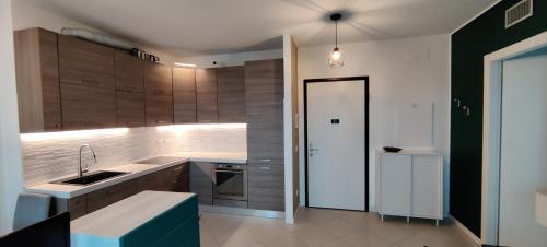 una cucina con armadi in legno, lavandino e frigorifero di Bloom Modern House - Milano a Milano