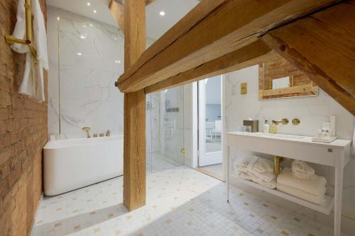 a bathroom with a white tub and a sink and a bath tub at Schloss Fellin Boutique Hotel and Spa in Viljandi