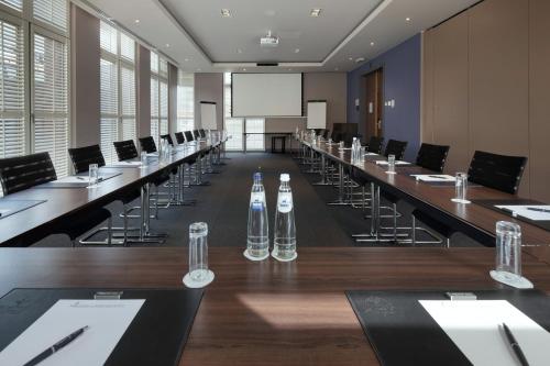 a conference room with tables and chairs and a screen at Martin's Klooster in Leuven