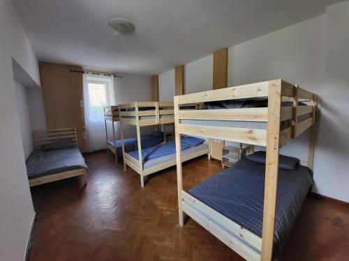 a room with three bunk beds in a room at Hostel pr Tanovmu Jozlnu in Mojstrana