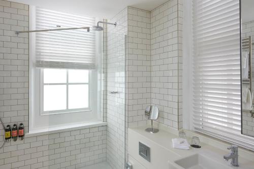 a white bathroom with a sink and a window at Hotel du Vin Exeter in Exeter