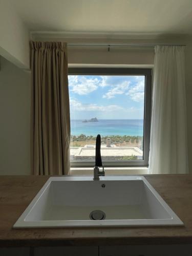 a kitchen sink with a view of the ocean at Almyra Villas in Xerokampos