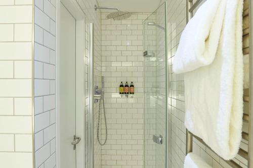 a bathroom with a shower with three bottles of wine at Hotel du Vin Exeter in Exeter