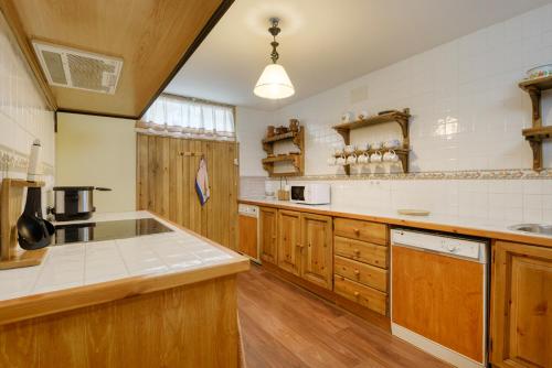 cocina grande con armarios de madera y electrodomésticos blancos en CASA RURAL PICO ASPE en Villanúa