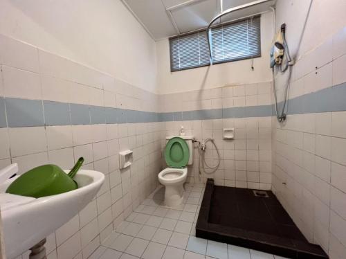 a bathroom with a green toilet and a sink at Maya Apartment Bay View Villas in Port Dickson