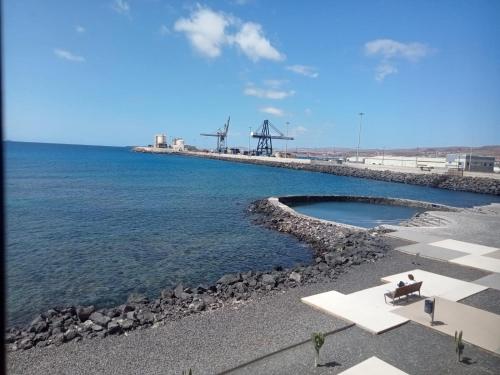 a beach with a bench and the water at Appartement vista mar in Puerto del Rosario