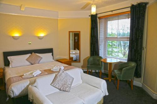 a hotel room with a bed and a chair and a table at Westberry Hotel in Bodmin