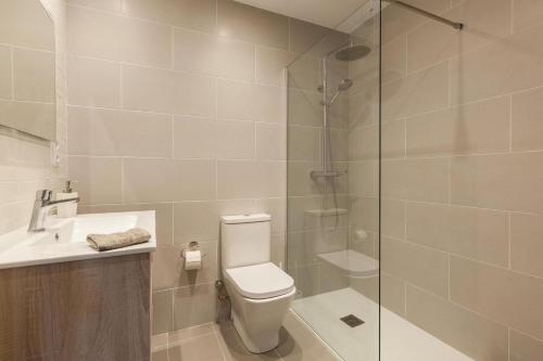 a bathroom with a toilet and a glass shower at L'aviador de Can Ton in Sant Llorenc Savall