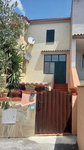 a house with a wooden fence in front of it at Appartamento in zona residenziale in Orosei