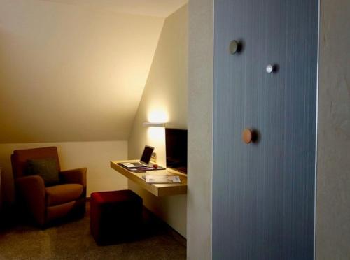 a hotel room with a desk and a chair at Landhotel Broda in Neubrandenburg