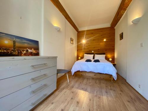 a bedroom with a bed and a dresser in a room at L'Armagnac in Carcassonne