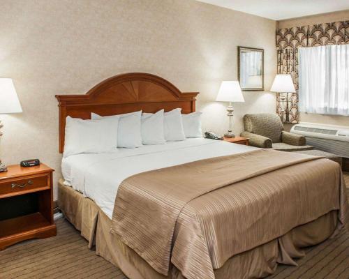 una habitación de hotel con una cama grande y una silla en Quality Inn Indianapolis, en Castelton