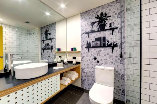 ein Bad mit einem WC, 2 Waschbecken und einem Spiegel in der Unterkunft Atura Albury in Albury