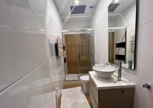 a white bathroom with a sink and a toilet at Casa do Gaspar in Aveiro
