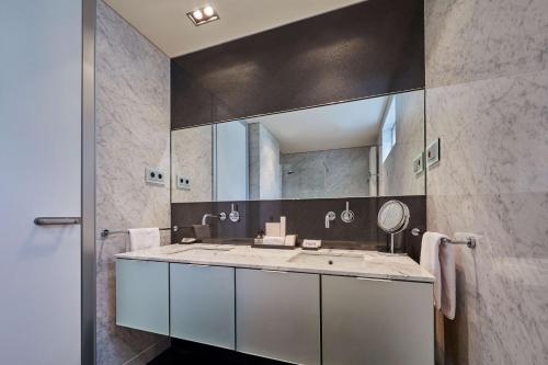 a bathroom with a sink and a mirror at Hyatt Regency Madrid Residences in Madrid