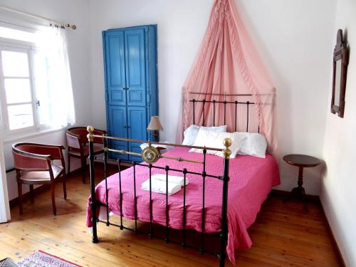1 dormitorio con 1 cama con manta rosa en Villa Archondisa, en La Canea