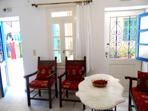sala de estar con sillas, mesa y ventanas en Villa Archondisa, en La Canea