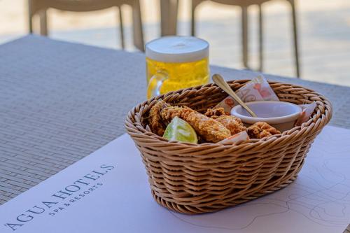 a basket of food and a glass of beer on a table at Agua Hotels Sal Vila Verde in Santa Maria