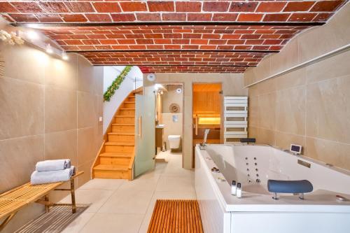 baño con bañera y escalera en Sospa - Suite spa privatif, en La Falaise