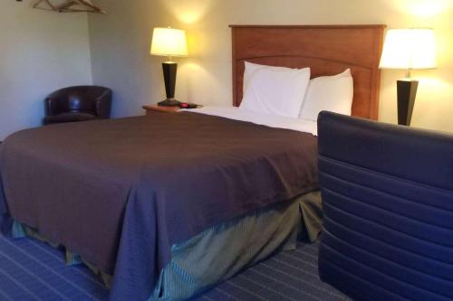 une chambre d'hôtel avec un lit et une chaise dans l'établissement Super 8 by Wyndham Vancouver East, à Vancouver
