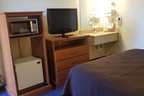 a hotel room with a television and a sink at Super 8 by Wyndham Vancouver East in Vancouver