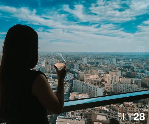 a woman drinking a glass of wine in a city at Kenzi Tower Hotel in Casablanca