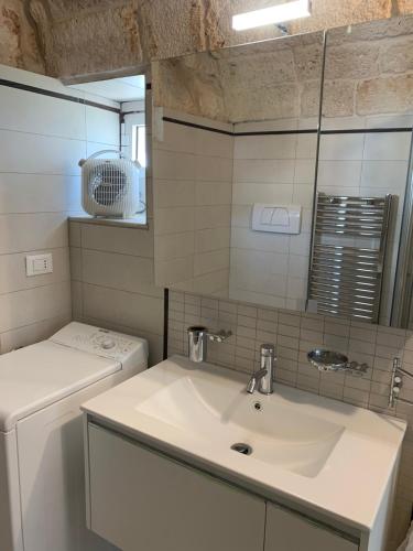 a bathroom with a sink and a washing machine at Casa Margherita in Ostuni