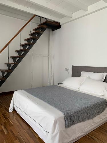 a white bedroom with a bed and a staircase at Casa Margherita in Ostuni