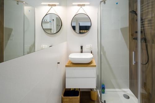 a bathroom with a sink and a shower at Powiśle 4 by Homeprime in Krakow