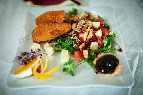 a white plate with a salad and food on it at Hotel Kapos in Kaposvár