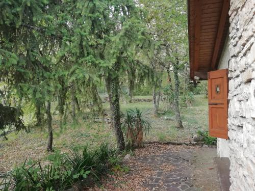 uma porta de uma casa com árvores ao fundo em La casetta nel bosco em Salò