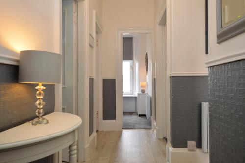 a hallway with a table and a lamp on it at Findhorn Upper Apartment in Kames