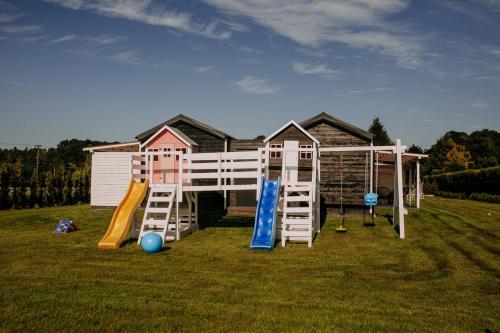 a house with a playground with a slide at Domki Energylandia Zator Przybradz in Przybradz