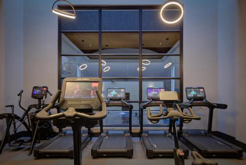 a gym with several exercise bikes and a tv at Oulton Hall Hotel, Spa & Golf Resort in Leeds