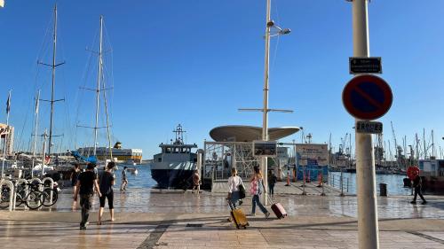 a group of people walking around a marina with boats at Vue sur rade appartement élégant vaste climatisé étage élevé ascenseur proche parking et toutes commodités au cœur du Toulon historique in Toulon