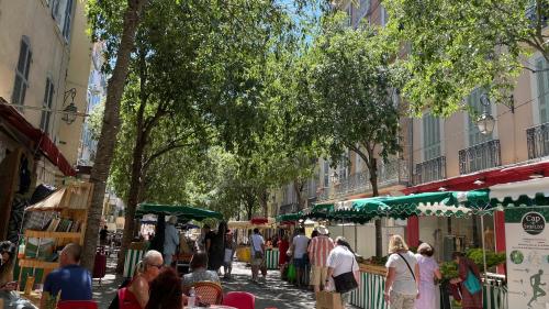 a group of people walking down a street with trees at Vue sur rade appartement élégant vaste climatisé étage élevé ascenseur proche parking et toutes commodités au cœur du Toulon historique in Toulon