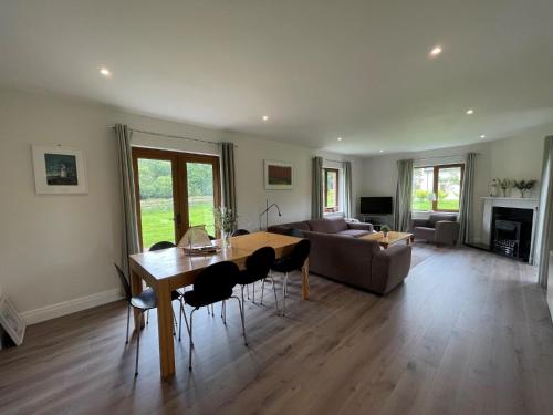 a living room with a table and a couch at No 2 Ardnagashel Woods in Ballylickey