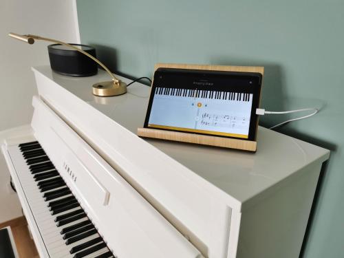 a laptop sitting on top of a white piano at Neues City Center Piano Appartement mit Netflix in Klagenfurt
