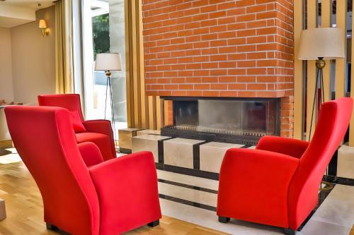 a living room with red chairs and a fireplace at The Sign Degirmen Hotel&Spa Wellness in Istanbul