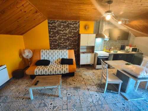 un salon avec un canapé et une table et une cuisine dans l'établissement CARPE DIEM, à Châteauvieux