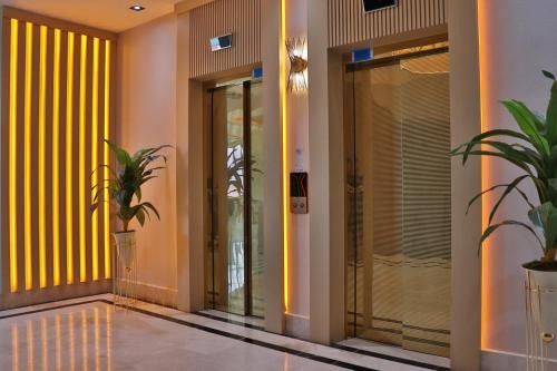 a hallway with glass doors and potted plants at The Sign Degirmen Hotel&Spa Wellness in Istanbul