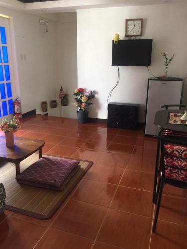 a living room with a tiled floor with a table and a tv at Hope Inn in Bolod