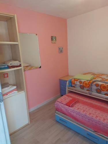 1 dormitorio pequeño con 1 cama y 1 litera en Paraiso S, en Villasimius