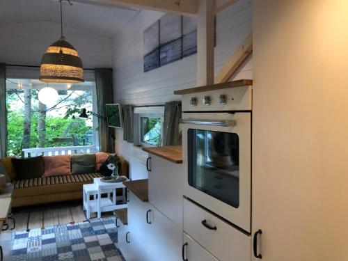 a kitchen with an oven and a living room at Domki Mojo Miodno Checz Sasino in Sasino