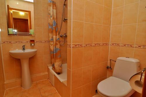 a bathroom with a toilet and a sink and a shower at Hotel Orion in Morshin