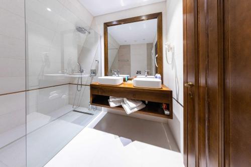 a bathroom with two sinks and a mirror at CABANELE IULI'S HOME in Runcu
