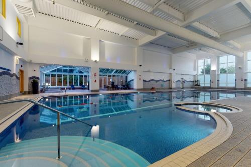 a large indoor swimming pool in a building at Village Hotel Bournemouth in Bournemouth